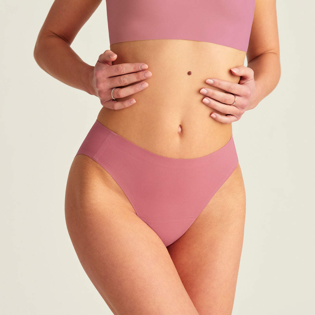 Modell trägt ooia Slip Seamless in Dusky Pink – nahtlose Periodenunterwäsche im klassischen Schnitt.