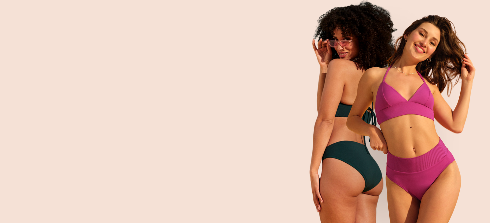 Zwei Models tragen grüne und pinke Perioden-Bikinis und posieren vor der Kamera