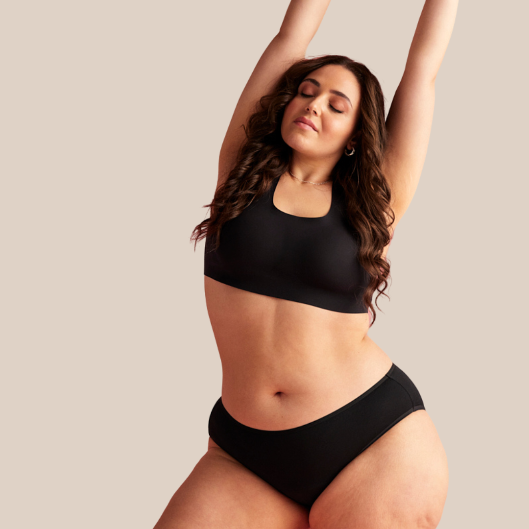 Model dehnt sich in schwarzer nahtloser Periodenunterwäsche 