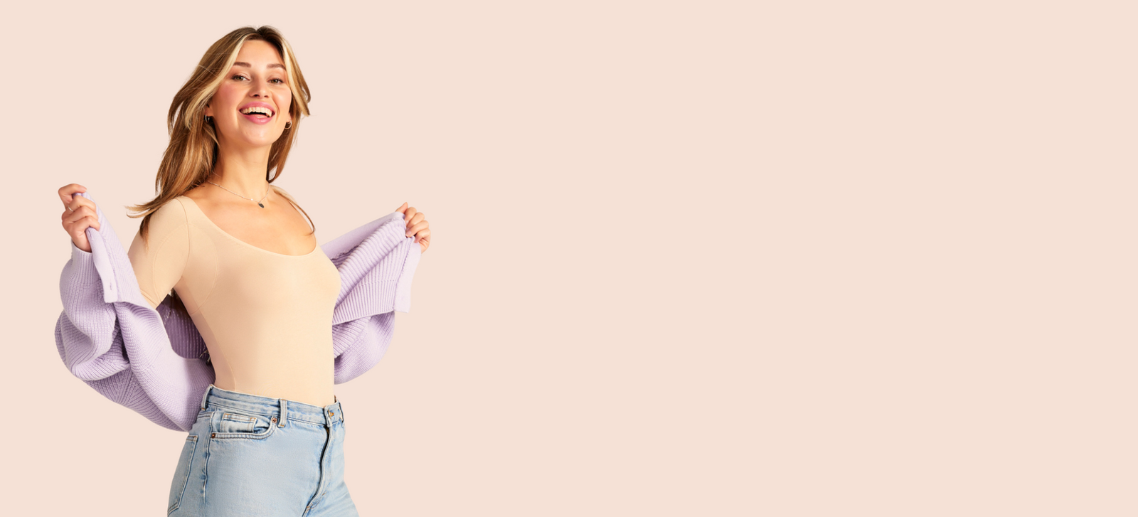 Model lächelt und trägt ein beiges Feel Dry Top von ooia mit einem flieder Cardigan.