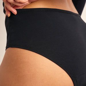 Modell trägt ooia Periodenunterwäsche Hipster Comfy Cotton in schwarz aus Baumwolle. 
seite