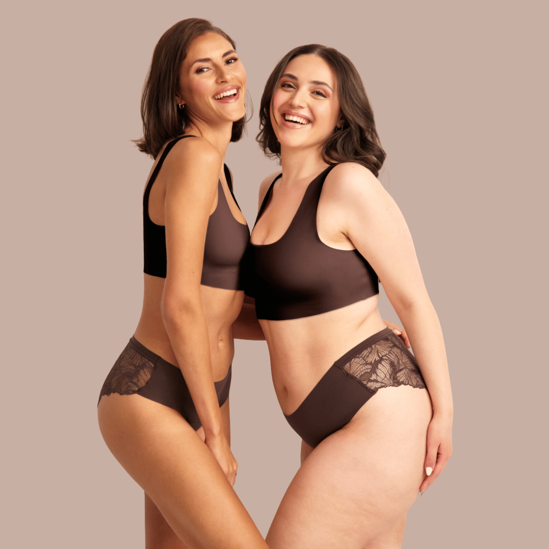 Zwei Model stehen eng aneinander und lachen, während sie nahtlose cocoa Lace Periodenunterwäsche von ooia tragen 