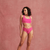 Model trägt pinken lace Periodenslip von ooia und posiert vor einem rosa Hintergrund