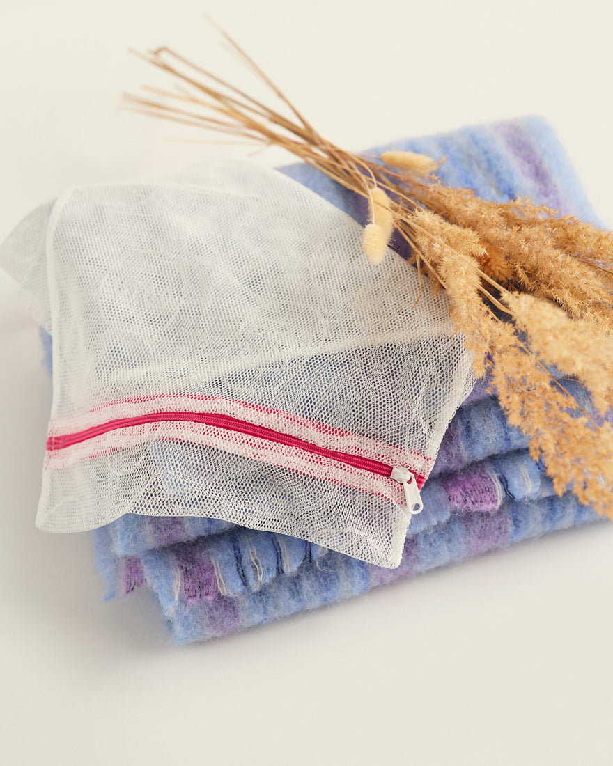 Ooia Washbag aus feinmaschigem Netzmaterial – ideal zum Waschen von Periodenunterwäsche in der Maschine. ooia Washbag liegt auf Handtüchern.