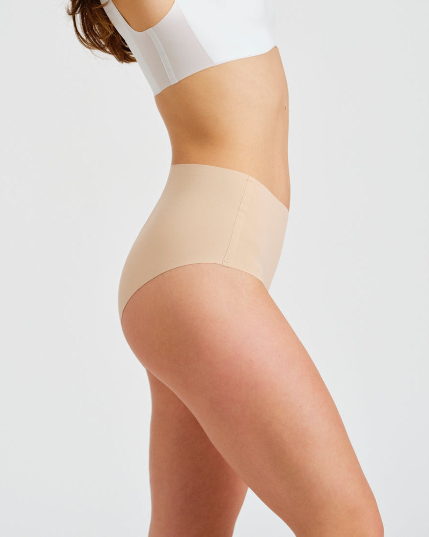 Modell trägt ooia everyday Highwaist Seamless in Beige – nahtlose Unterwäsche mit hohem Bund, die Slipeinlagen ersetzt
