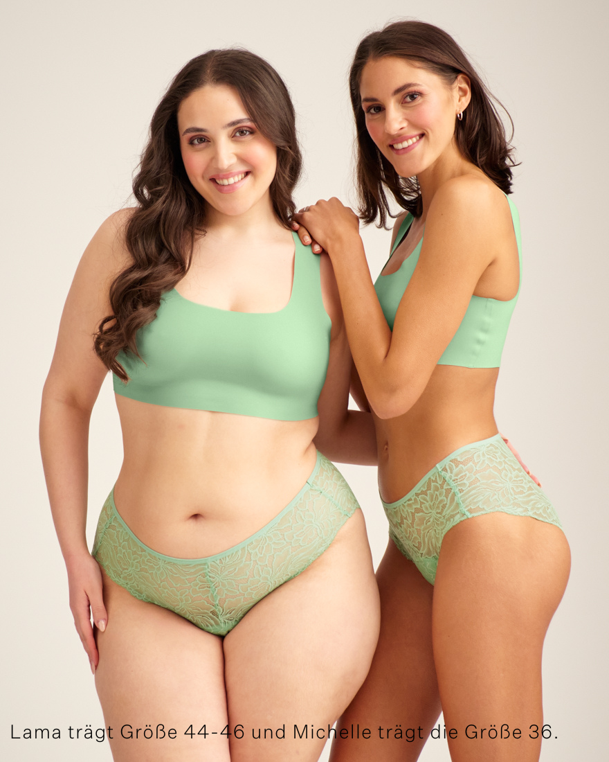 Zwei Models unterschiedlicher Konfektion ooia Hipster Allover Lace in Bright Sage – Periodenslip mit durchgehender floraler Spitze