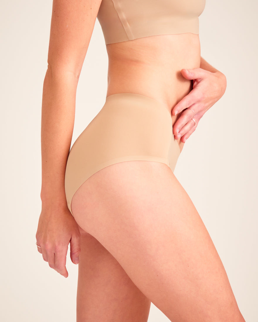 Modell trägt ooia Hipster Seamless in Beige – nahtlose Periodenunterwäsche.