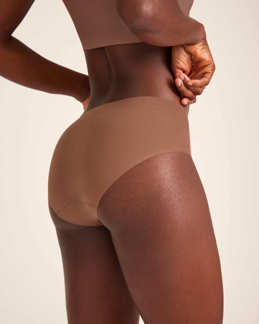 Modell trägt ooia Hipster Seamless in Braun – nahtlose Periodenunterwäsche.