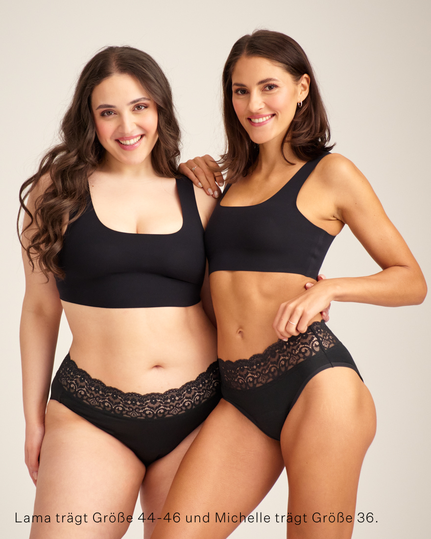Zwei Models unterschiedlicher Konfektion tragen ooia Slip Extra Strong in Schwarz – Periodenunterwäsche mit breitem Spitzenbund im klassischen Schnitt.