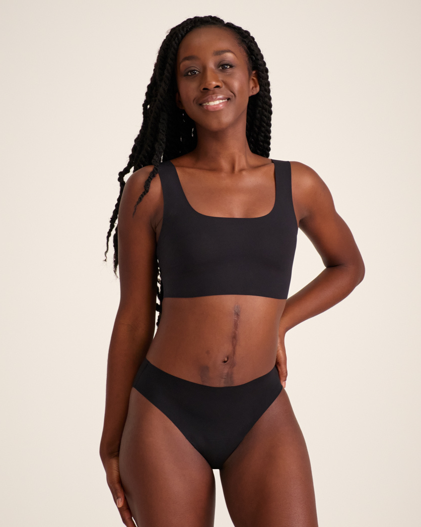 Modell trägt ooia Slip Seamless in Schwarz – nahtlose Periodenunterwäsche im klassischen Schnitt.