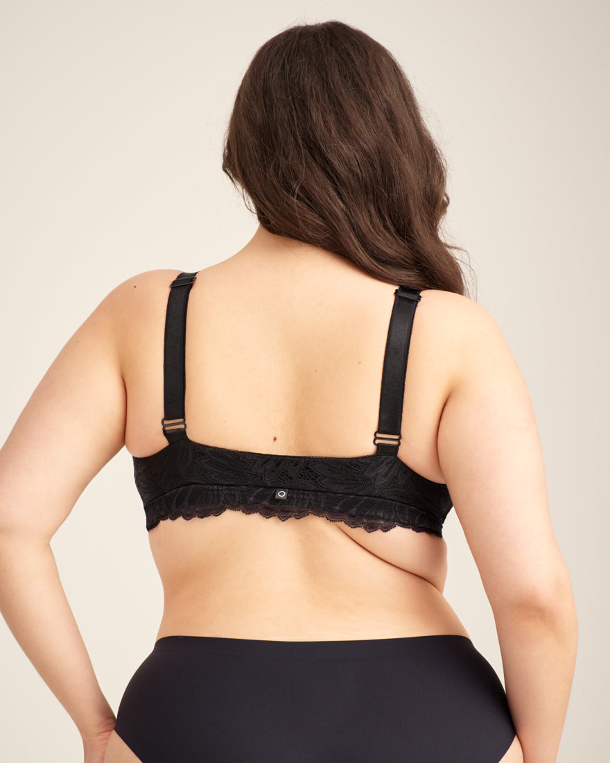 Modell trägt ooia Moms Still-BH Lace in Schwarz – eleganter Still-BH, der Stilleinlagen ersetzt. Rückansicht.
