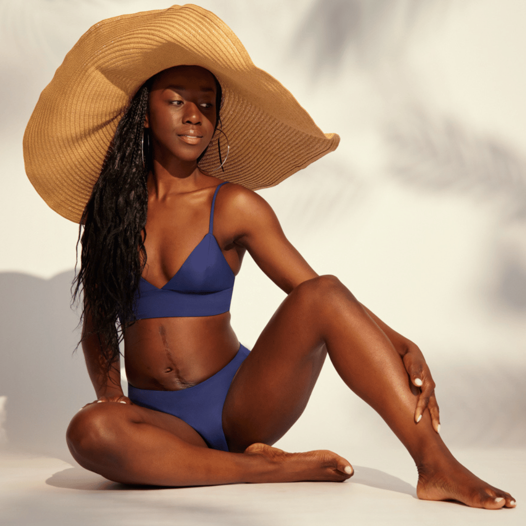 Model trägt Perioden Beachwear in ozeanblau und einen Strandhut