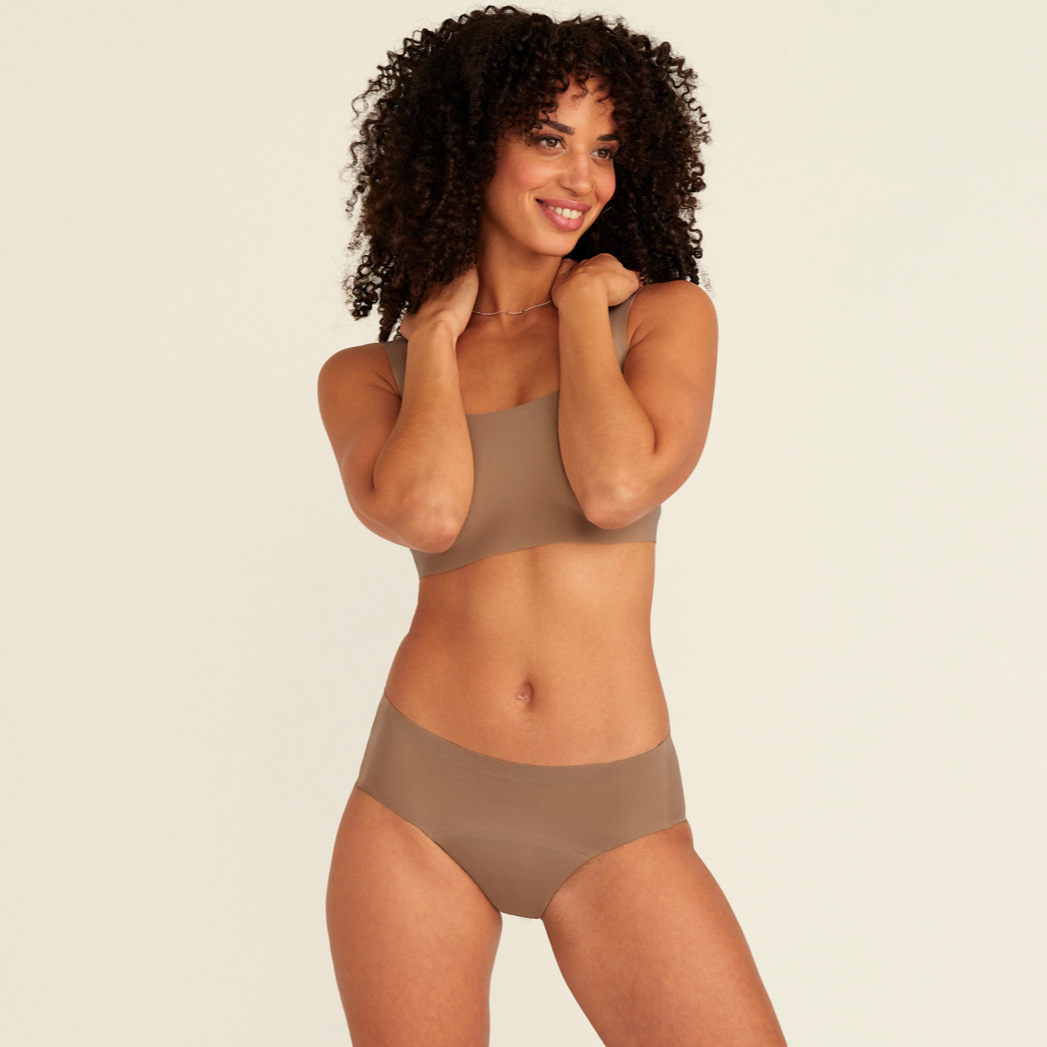 Modell trägt ooia Periodenunterwäsche Hipster Seamless in Taupe mit nahtlosem Design