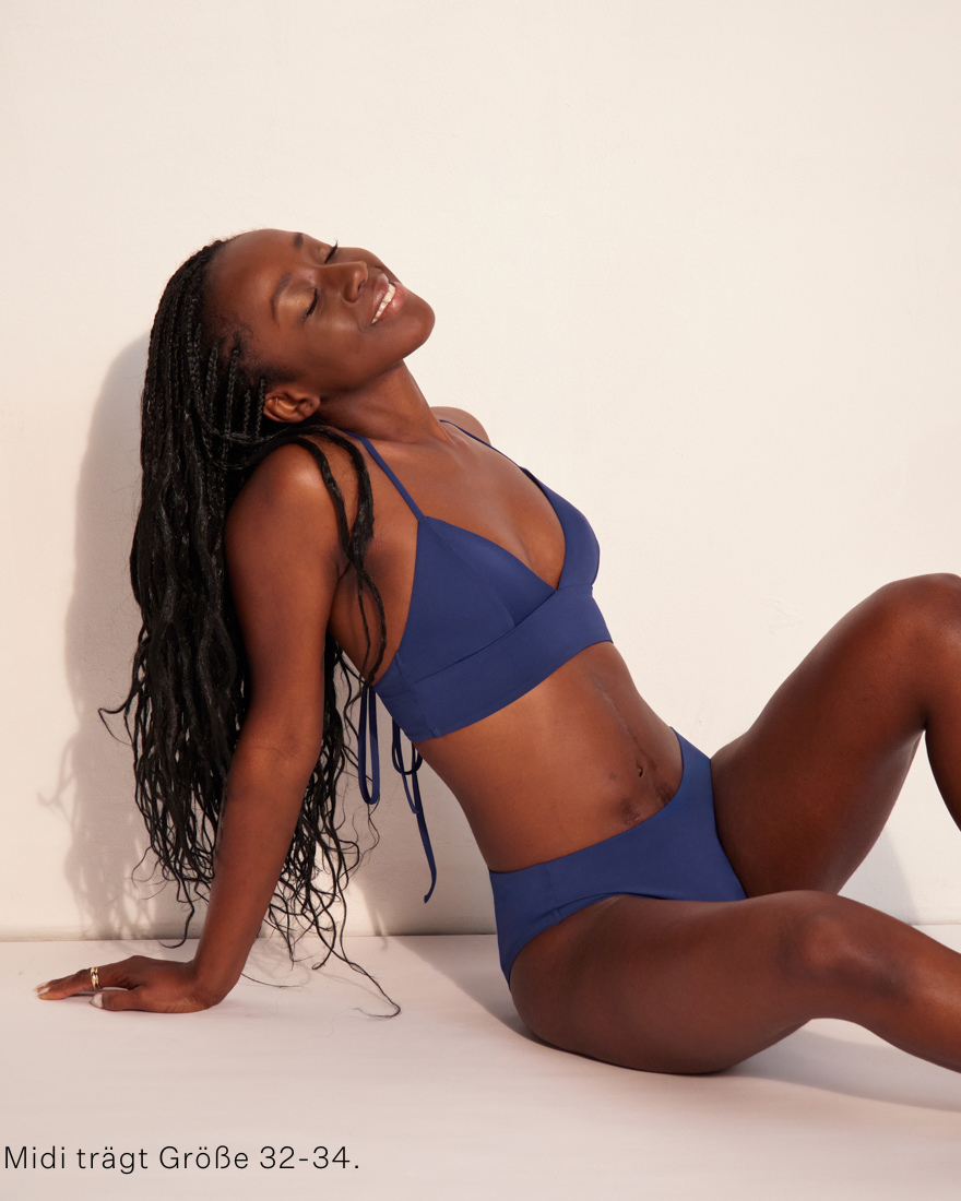 Modell trägt ooia Beach Triangle Top in Ozeanblau –  Bikini-Top im klassischen Triangle Shape mit verstellbaren Trägern.