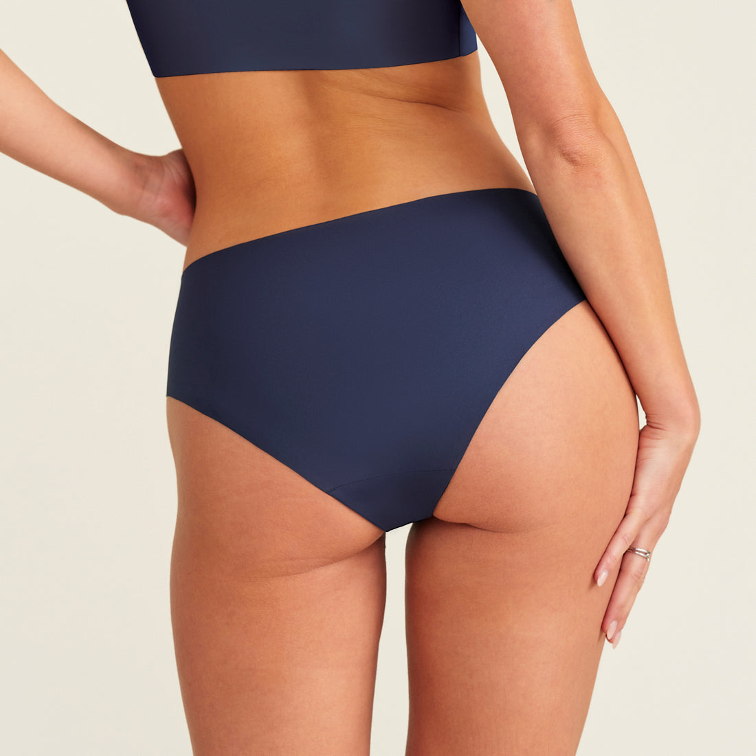 Modell trägt ooia Everyday Hipster Seamless in Midnight – Unterwäsche ersetzt Slipeinlage, Rückansicht