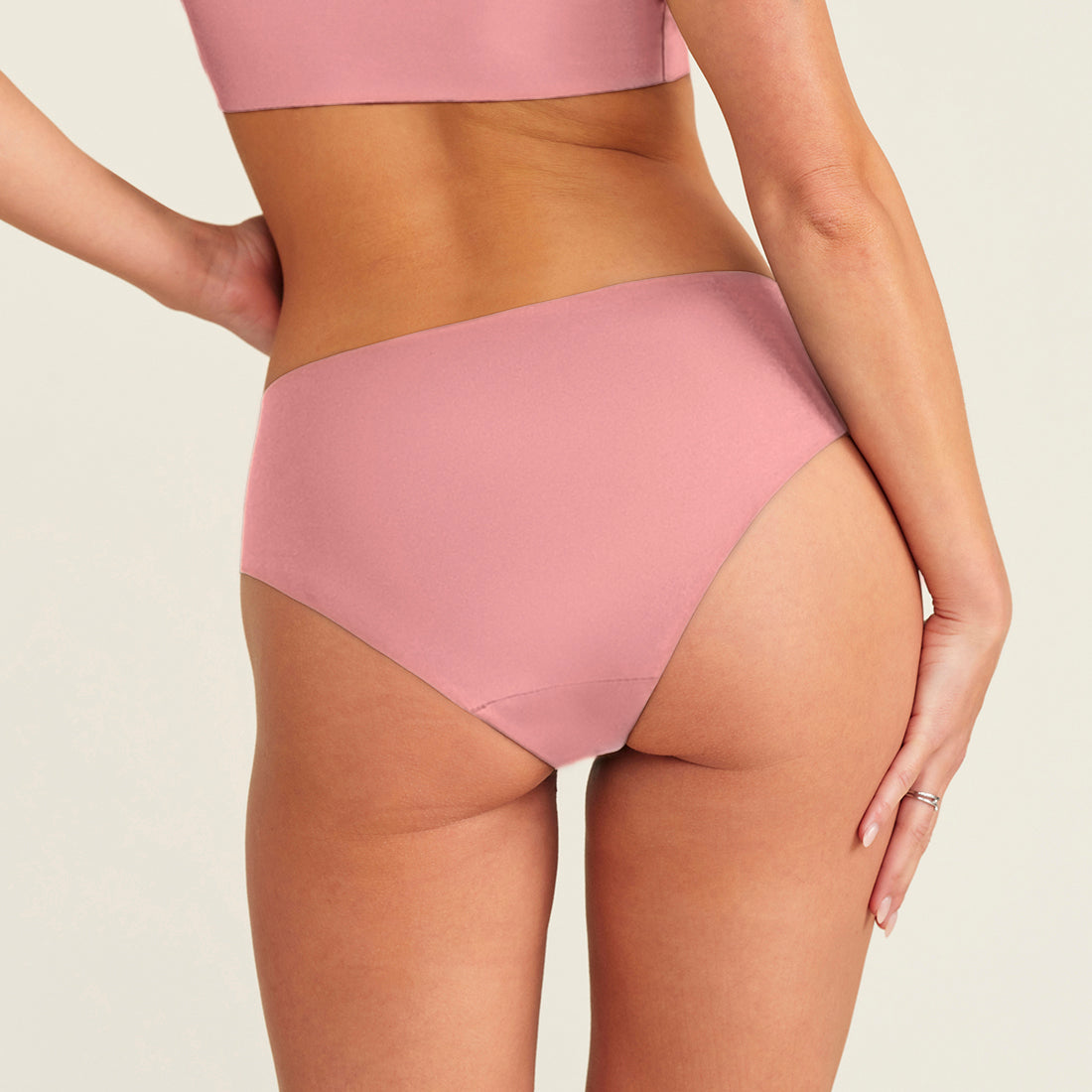 Modell trägt ooia everyday Hipster Seamless in Dusky Pink - Unterwäsche die Slipeinlagen ersetzt. Rückansicht.