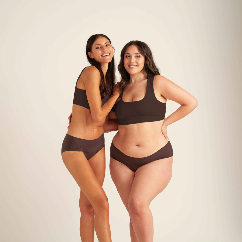 Zwei Models, die nahtlose cocoa Periodenslips tragen und lächelnd in die Kamera schauen