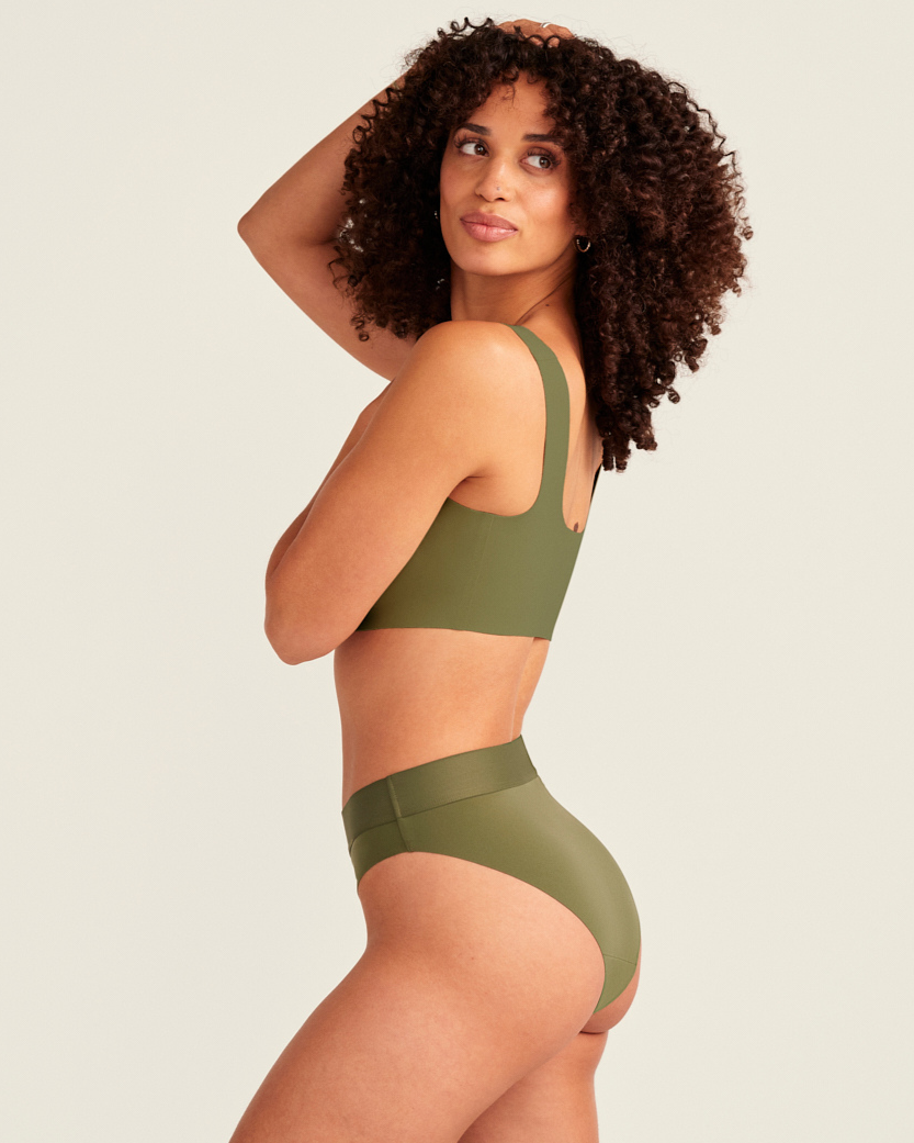 Modell trägt ooia Periodenslip Seamless Cheeky Periodenslip in Khaki mit hohem Beinausschnitt