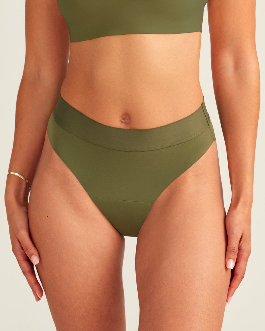 Modell trägt ooia Periodenslip Seamless Cheeky Periodenslip in Khaki mit hohem Beinausschnitt