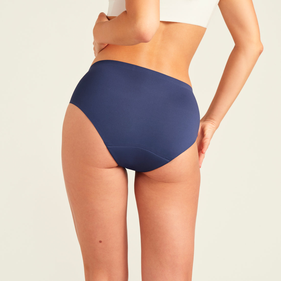 Modell trägt ooia Hipster Seamless in Midnight - nahtlose Periodenunterwäsche. Rückansicht.