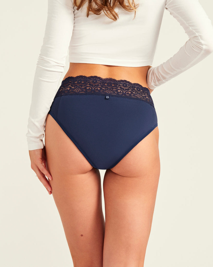 Modell trägt ooia Periodenslip Extra Strong in Midnight mit breiter Spitze am Bund. Rückansicht.