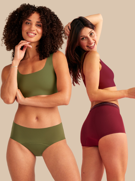 Zwei Models liegen seitlich auf dem Boden und tragen nahtlose Periodenunterwäsche in beige und schwarz