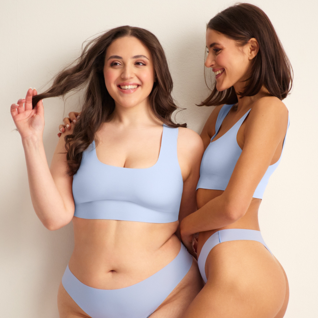 Zwei Models lächeln und tragen nahtlose Periodenunterwäsche in hellblau.
