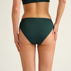 Hip-shot von hinten, eine Frau die einen  Grünen Perioden Badeanzug Slip von Ooia trägt